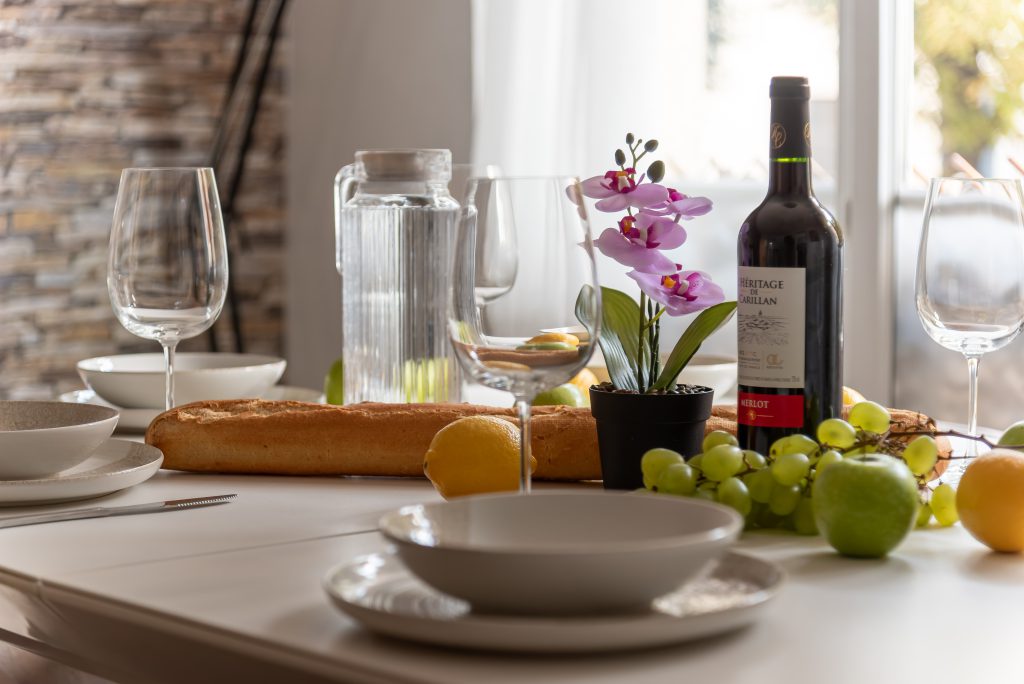 Design & identité Table dressée en lumière naturelle, orchidée, verres et matières chaleureuses.